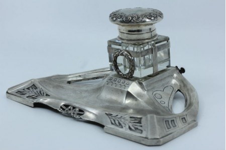 Tinteiro em prata recortada com depósito em vidro e tampa relevada .